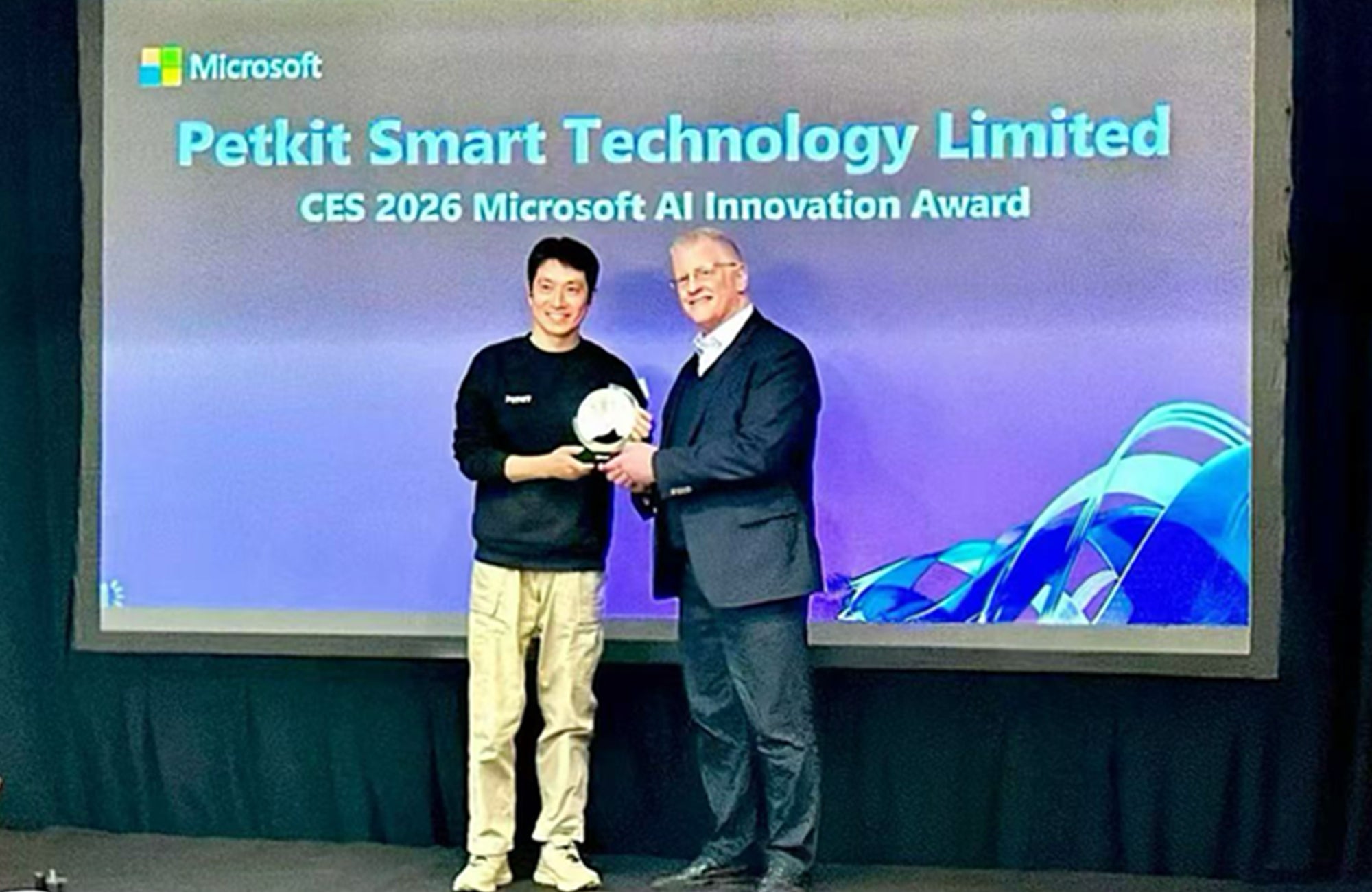 PETKIT CEO receiving the Microsoft AI Innovation Award at CES 2026, celebrating PETKIT’s AI Health achievement alongside the award presenter on stage