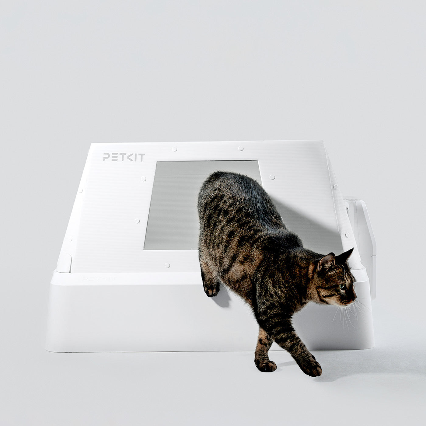 Front-Entry Hood helping contain crystal litter as a cat steps out of the PUROBOT CRYSTAL DUO, reducing tracking and keeping floors cleaner